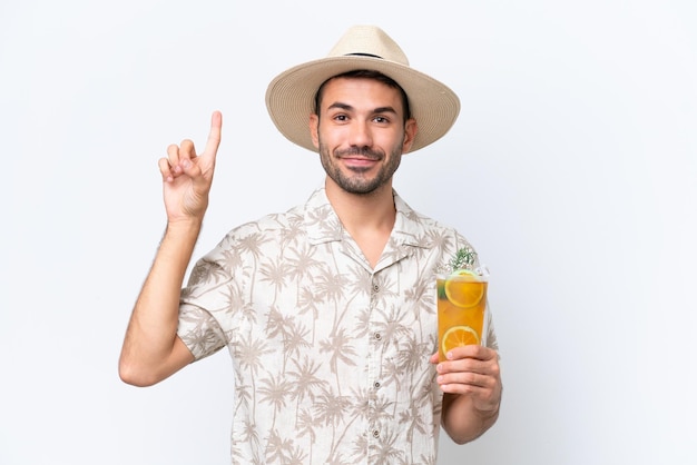 Junger kaukasischer Mann, der einen Cocktail lokalisiert auf weißem Hintergrund hält, der eine großartige Idee zeigt