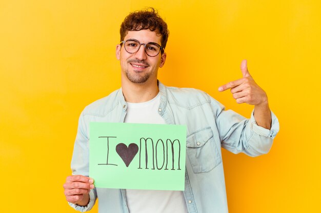 Junger kaukasischer Mann, der Papierblatt mit Text hält: Ich liebe Mutter