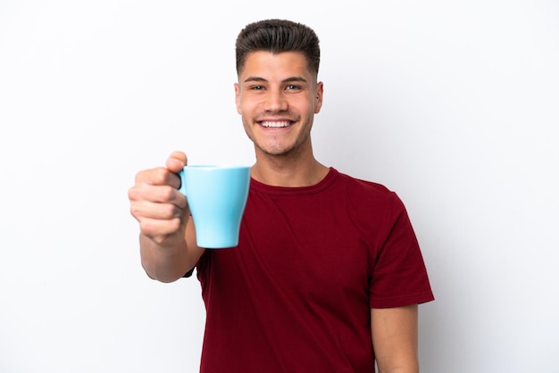 Junger kaukasischer mann, der tasse kaffee lokalisiert auf weißem hintergrund mit glücklichem ausdruck hält