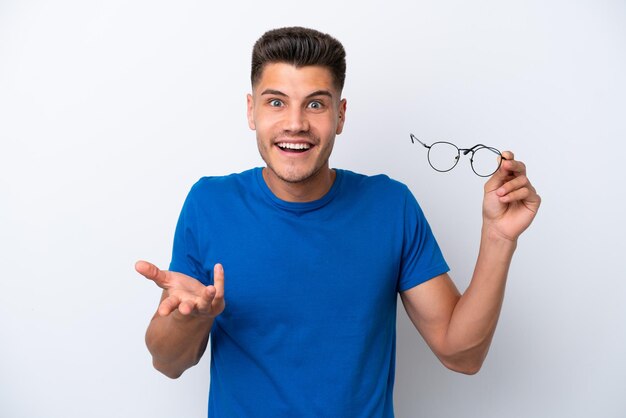 Junger kaukasischer Mann mit Brille isoliert auf weißem Hintergrund mit schockiertem Gesichtsausdruck