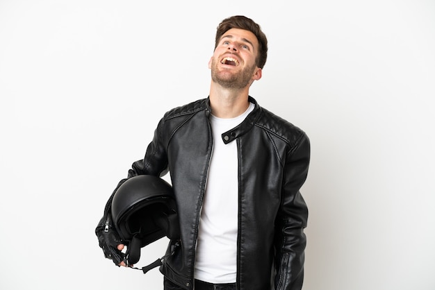 Junger kaukasischer Mann mit einem Motorradhelm isoliert auf weißem Hintergrund lachen