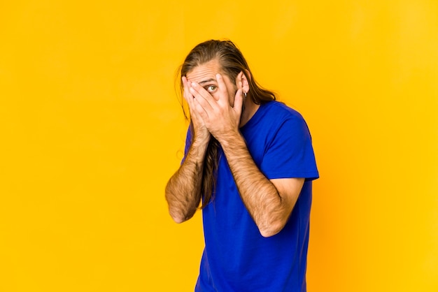 Junger kaukasischer Mann mit langen Haaren, der Gefühle isoliert ausdrückt