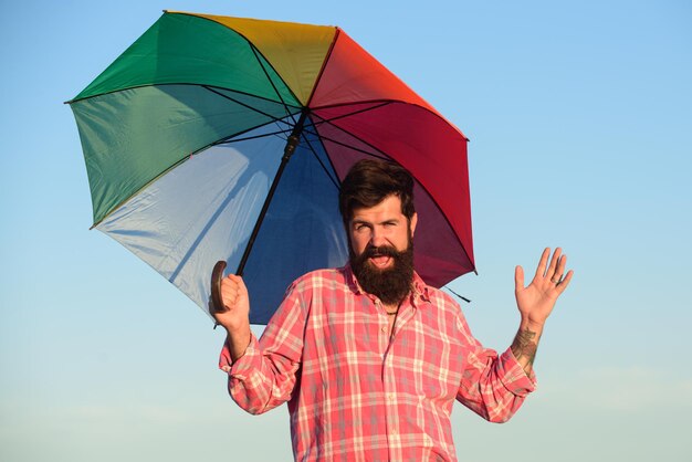 Junger kaukasischer Mann mit Regenbogenregenschirm. LGBT-Bewegung, Gay-Pride-Banner-Vorlage.