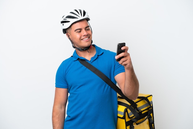 Junger kaukasischer Mann mit Thermorucksack isoliert auf weißem Hintergrund, der ein Selfie macht