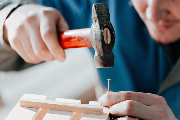 Junger kaukasischer Tischler in Arbeitskleidung stellt Holzkisten in der Tischlerei her Echte Szene Kleines Unternehmen