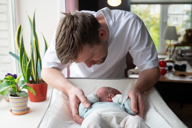 Junger kaukasischer Vater, der seine neugeborene Tochter umarmt