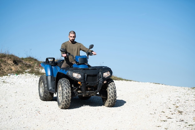 Junger Kerl fährt ein ATV im Freien