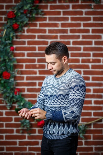 Junger Kerl in einem Sweatshirt gegen eine Mauer