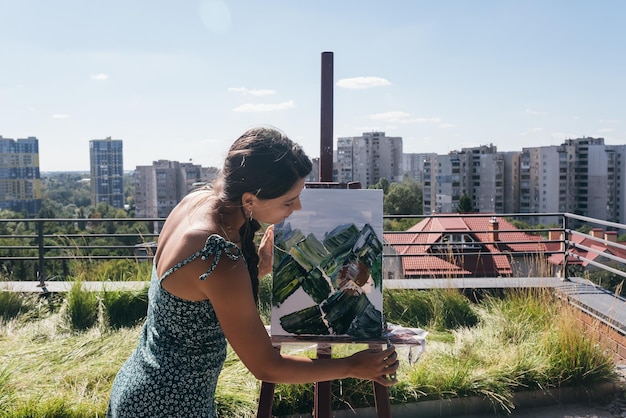 Junger Künstler malt vor dem Hintergrund der Stadt