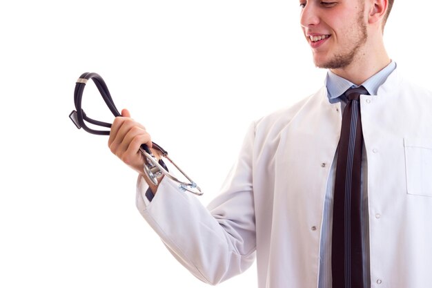 Junger lächelnder Mann mit braunen Haaren in blauer Hemdkrawatte und weißem Arztkittel mit seinem Stethoskop