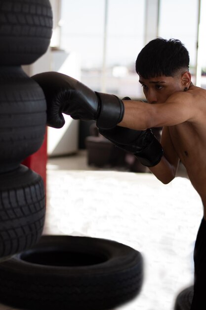 Junger Latino-Boxer, der einen Boxsack schlägt