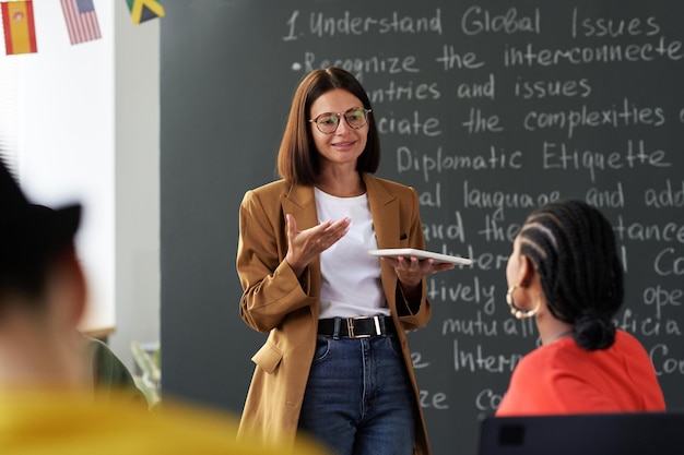 Junger Lehrer erklärt Schülern im Klassenzimmer Material