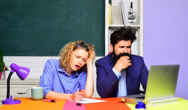 Junger Lehrer mit jungem Schüler im Klassenzimmer Schüler im College ernsthafte Schüler, die in der Schule studieren