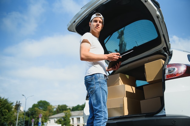 Junger Lieferer Checkliste auf Zwischenablage im Auto