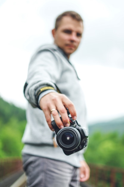 Junger männlicher Fotograf, der eine Kamera hält