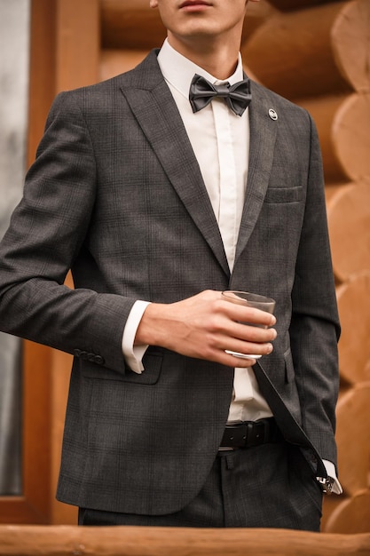 Junger männlicher Geschäftsmann kleidet einen stilvollen Anzug für ein wichtiges Treffen. Kleidung für einen erwachsenen Mann