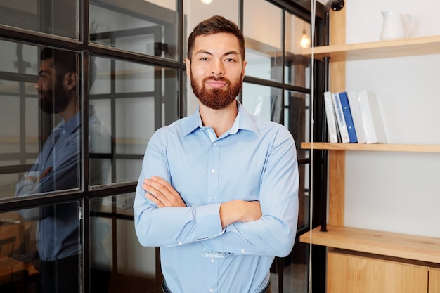 Junger Manager, der im Büro steht