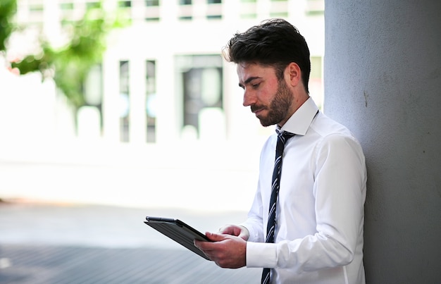 Junger Manager mit einem digitalen Tablet im Freien