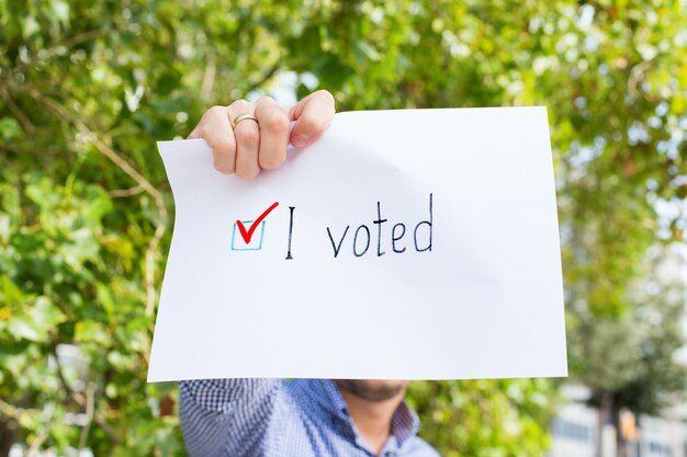 Foto junger mann, aktivist ruft zur abstimmung auf und hält papier mit der aussage, dass ich gewählt habe. politischer aktivismus, wahlprozess, konzept für aktive lebenspositionen. präsident, verfassungswahlen.