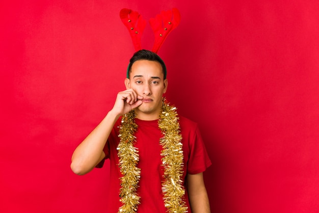 Foto junger mann am weihnachtstag mit den fingern auf den lippen ein geheimnis halten.