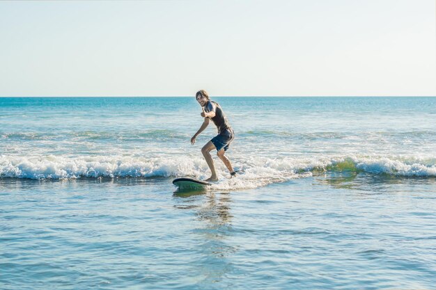 Junger Mann, Anfänger Surfer lernt das Surfen auf einem Meeresschaum auf der Insel Bali