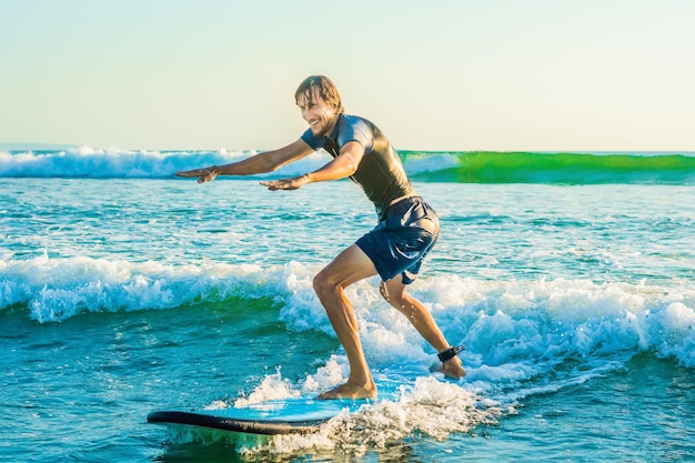 Junger Mann, Anfänger Surfer lernt das Surfen auf einem Meeresschaum auf der Insel Bali.