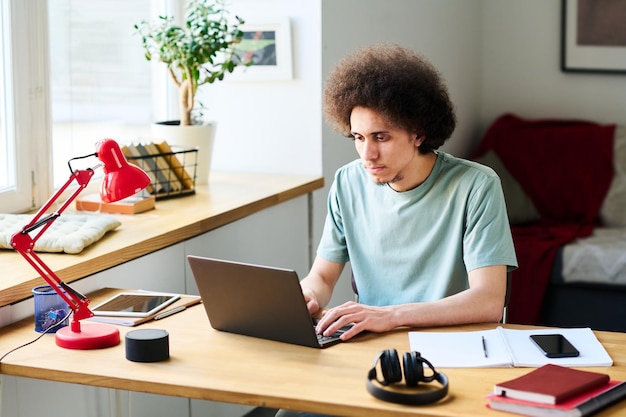 Foto junger mann arbeitet zu hause online am laptop