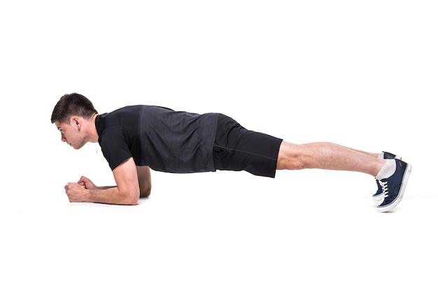 Junger Mann auf Bauchmuskeltraining Grundlegende Plankenhaltung auf Weiß