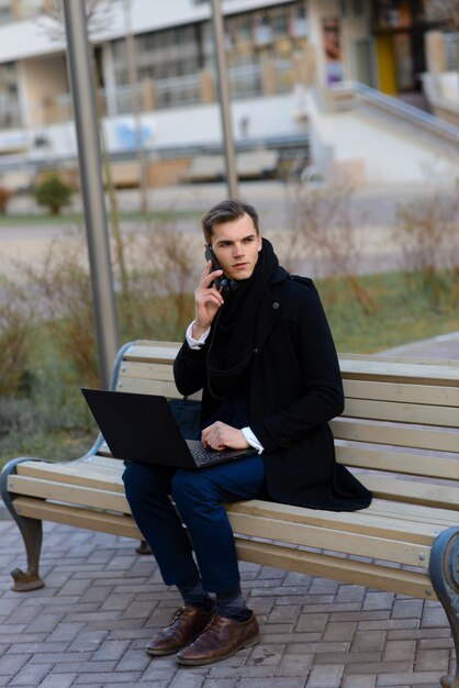 Junger Mann auf der Straße und im Café mit Handy, Computer.