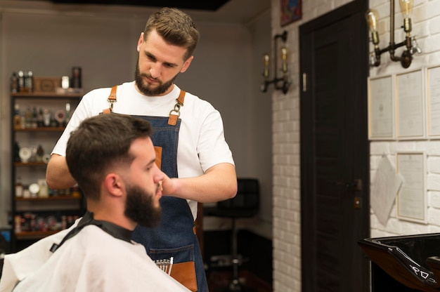 Foto junger mann beim friseur lässt sich die haare schneiden