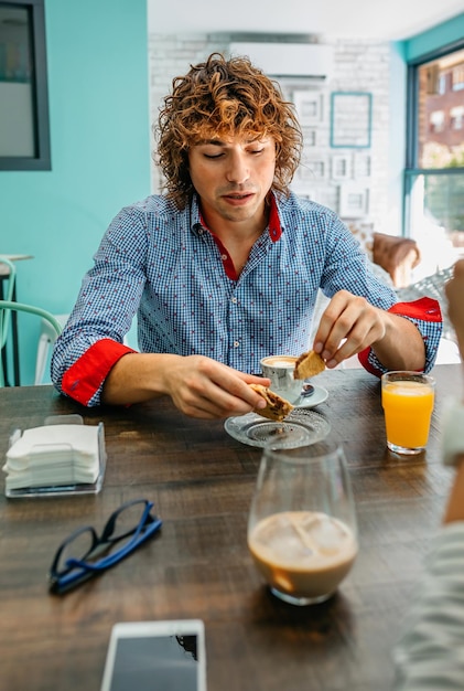 Junger Mann beim Frühstück im Café