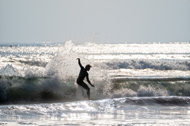 Junger Mann beim Surfen auf den Wellen des Pazifischen Ozeans