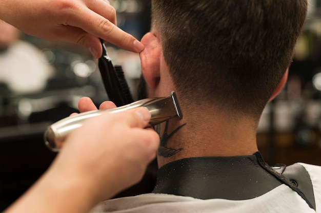 Junger Mann bekommt einen neuen Haarschnitt beim Friseur