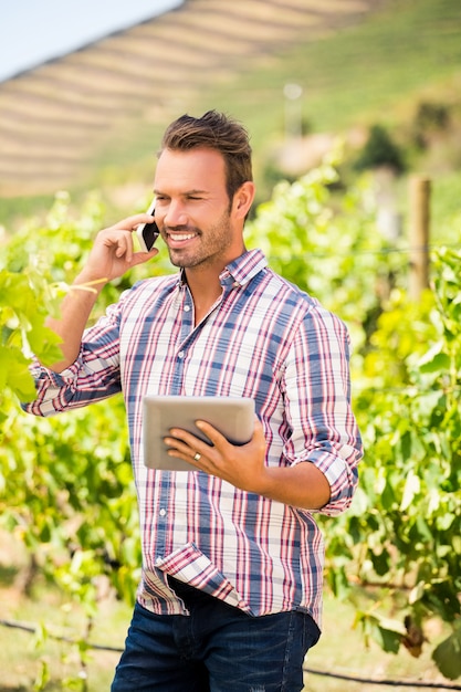 Junger Mann, der am Telefon am Weinberg spricht