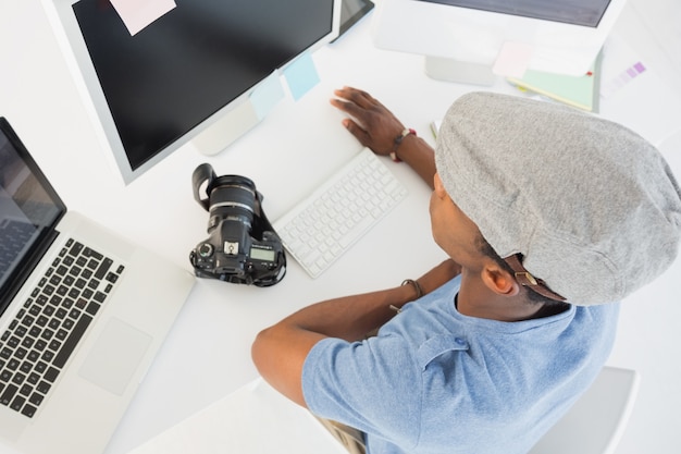 Junger Mann, der an Computer im Büro arbeitet