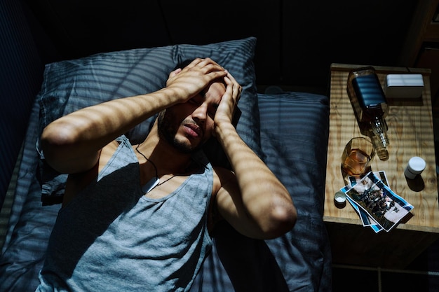 Junger Mann, der an Kopfschmerzen leidet, die durch ein posttraumatisches Syndrom verursacht werden