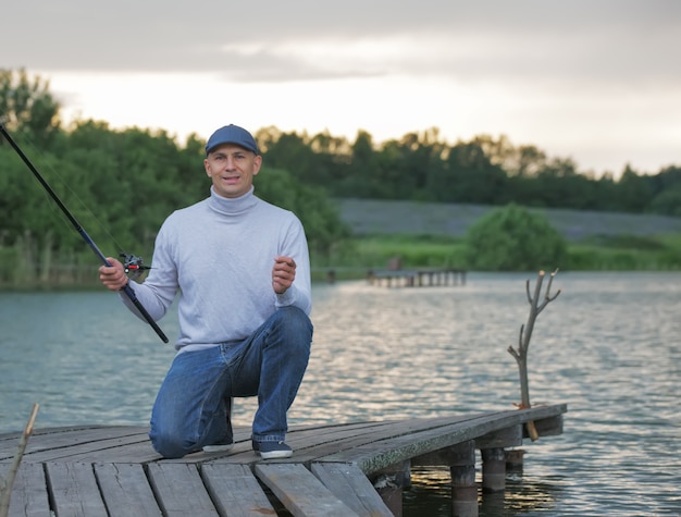 Junger Mann, der auf einem See fischt