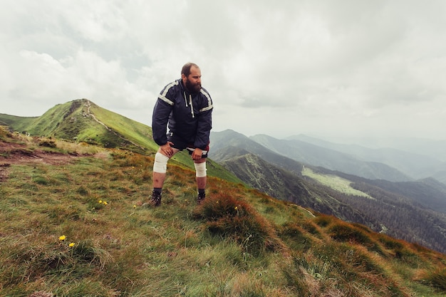 Junger Mann, der auf einer Klippe steht und den Blick auf die Natur genießt