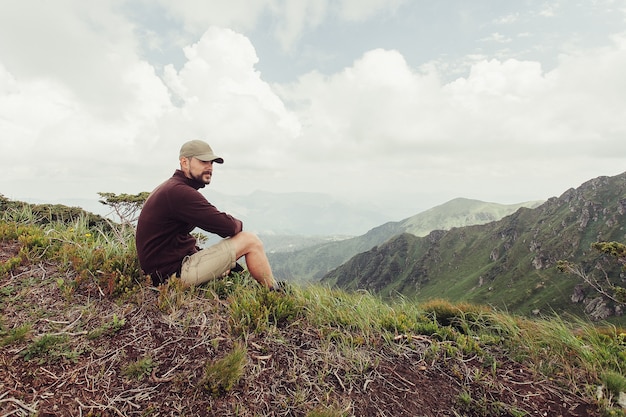 Junger Mann, der auf einer Klippe steht und den Blick auf die Natur genießt