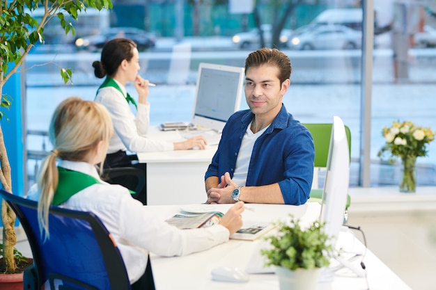 Junger Mann, der Bankmanager hört