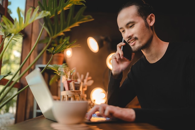 Junger Mann, der Computer-Laptop oder Tablet für die Arbeit verwendet und Online-Kommunikation von zu Hause aus lernt, Cyberspace-Bildungstechnologie für Geschäftsleute oder Studenten, die zur Arbeit arbeiten, Hipster-Geschäftsmann