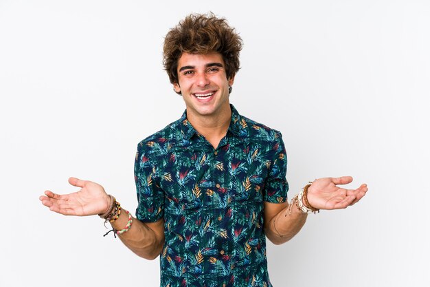 Junger Mann, der ein Blument-shirt zeigt einen willkommenen Ausdruck trägt