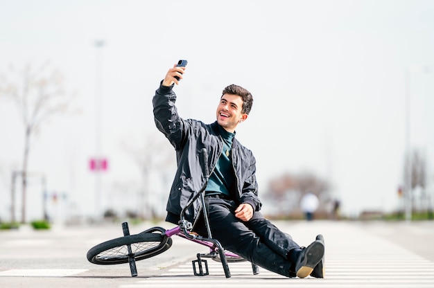 Junger Mann, der ein Foto mit Smartphone mit seinem Fahrrad macht