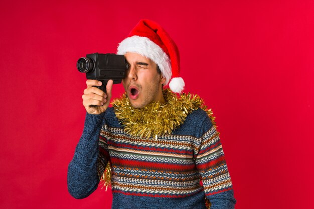 Junger Mann, der ein Geschenk am Weihnachtstag hält