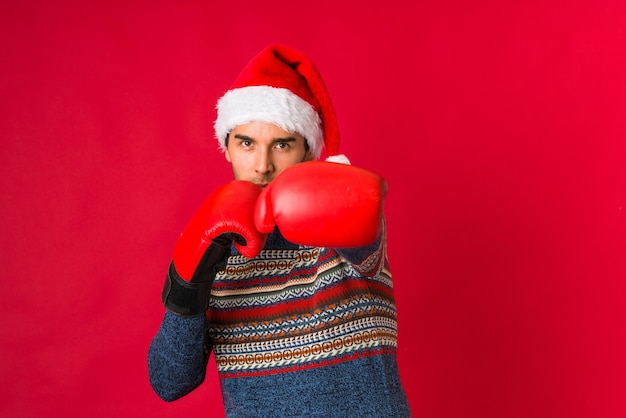 Junger Mann, der ein Geschenk am Weihnachtstag hält