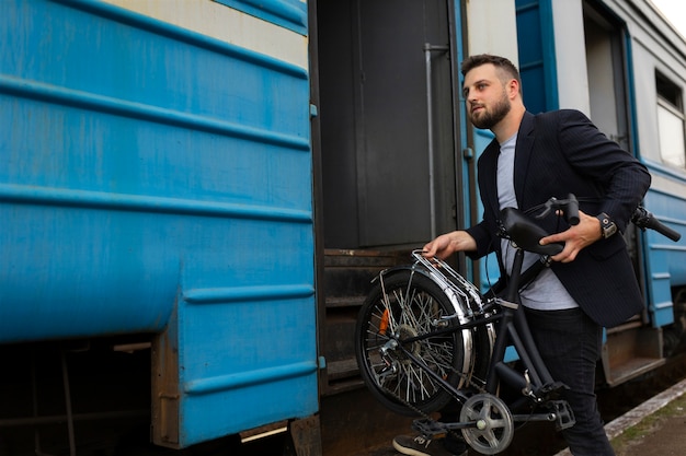 Foto junger mann, der ein klapprad benutzt, während er mit dem zug fährt