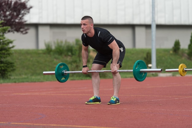 Junger Mann, der eine Dead-Lift-Übung im Freien macht