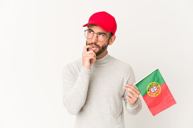 Junger Mann, der eine Portugalflagge hält