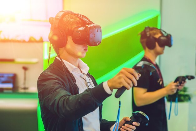 Junger Mann, der eine Virtual-Reality-Brille von Videospielen spielt. Fröhlicher Mann, der Spaß mit der neuen Trendtechnologie hat - Gaming-Konzept