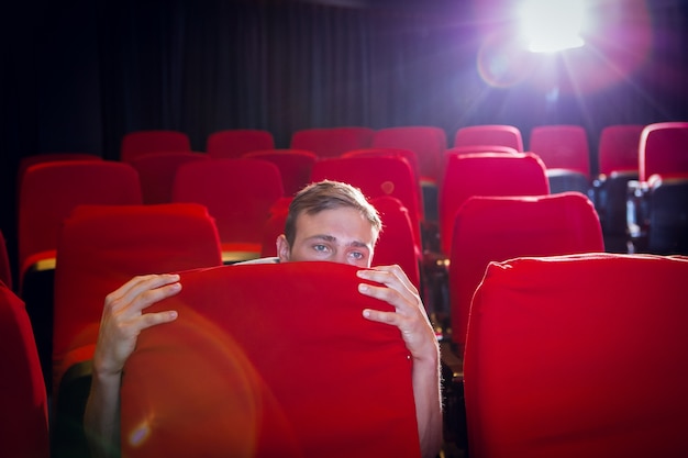 Junger Mann, der einen furchtsamen Film aufpasst